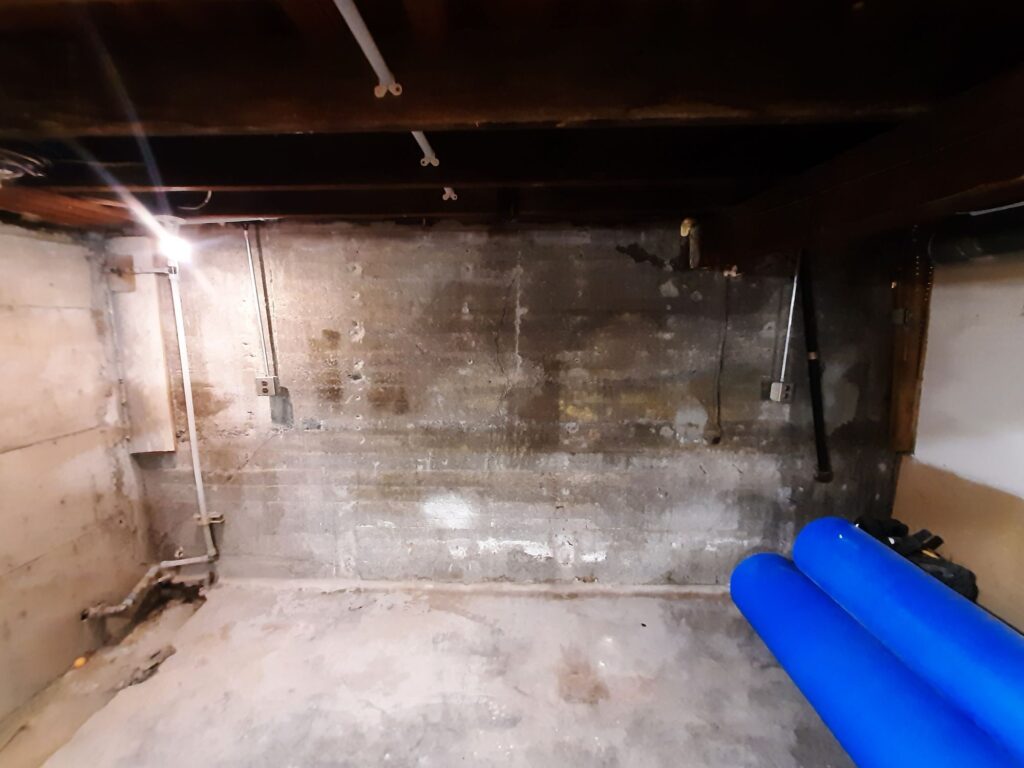 Empty basement with concrete walls.