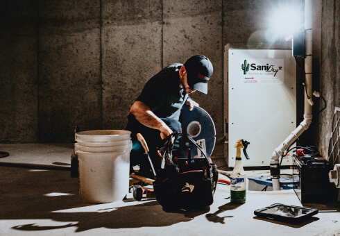 TerraFirma specialist installing a sump pump as part of a complete foundation waterproofing system