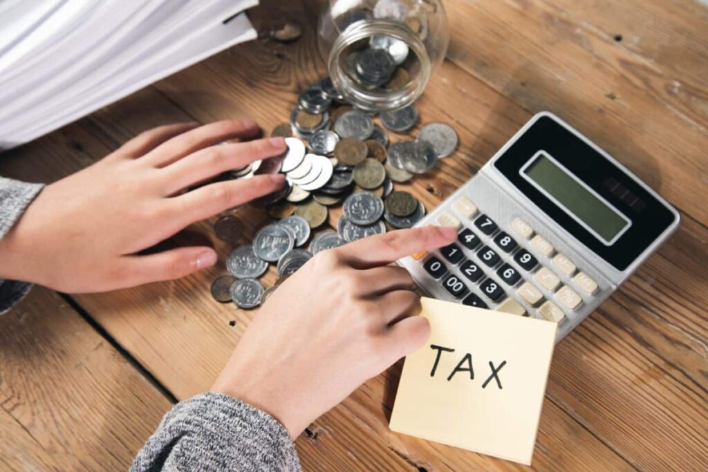 What One Big Beautiful Bill Means for Homeowners woman working calculator with tax coins bill