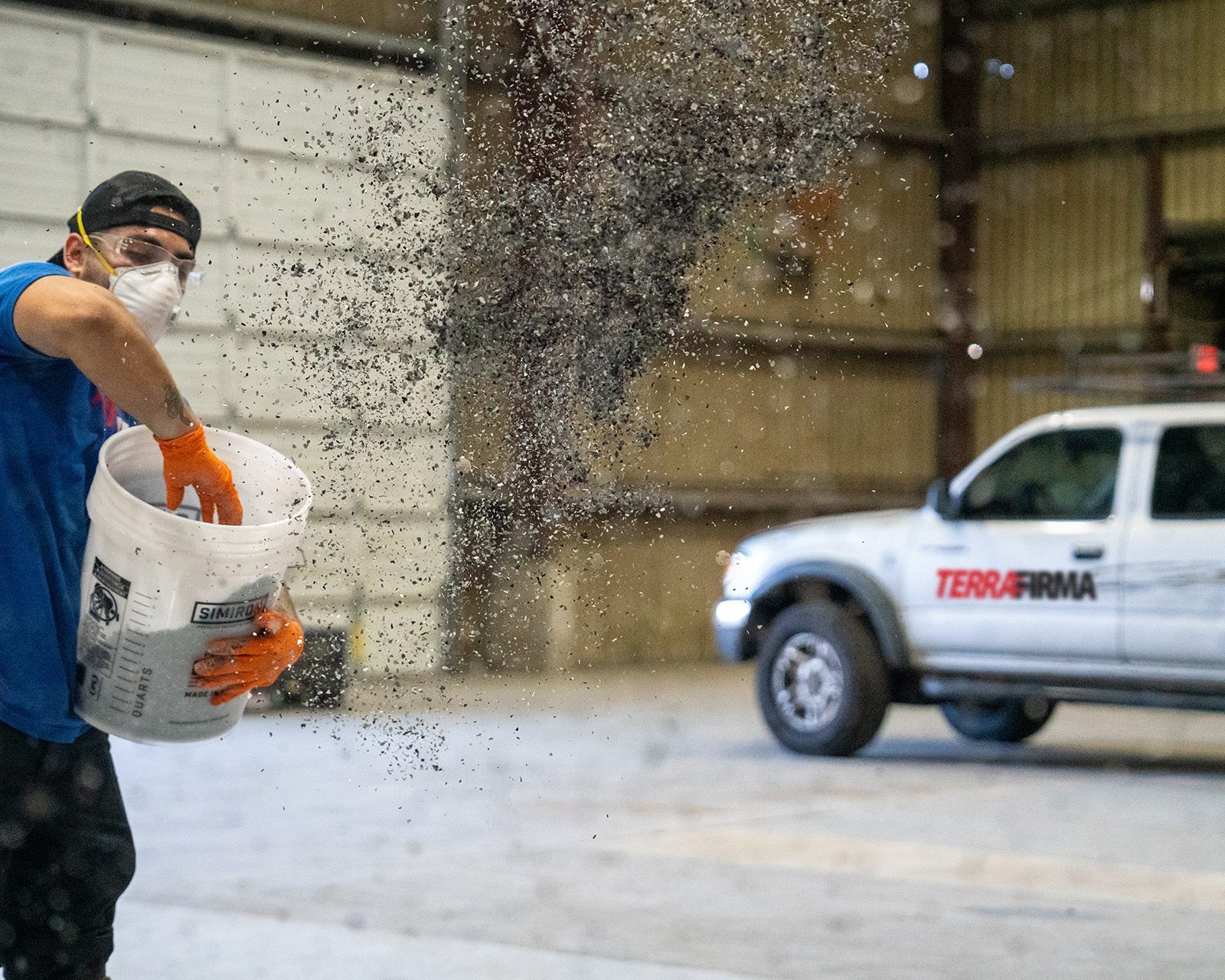 TerraFirma technician broadcasting decorative vinyl flakes during floor coating work