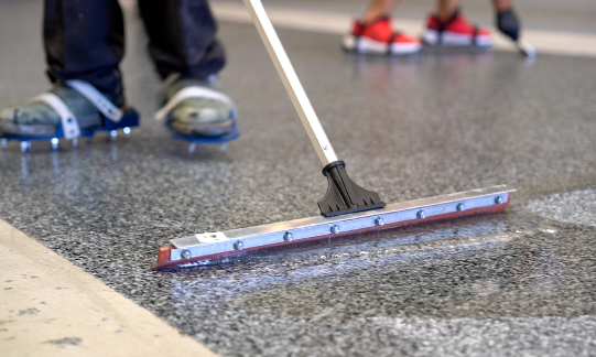 Applying final epoxy floor coating in Olympia